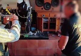 Dos agentes inspeccionan los elementos encontrados en la operación.