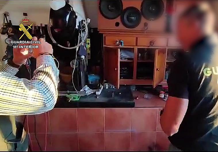 Dos agentes inspeccionan los elementos encontrados en la operación.