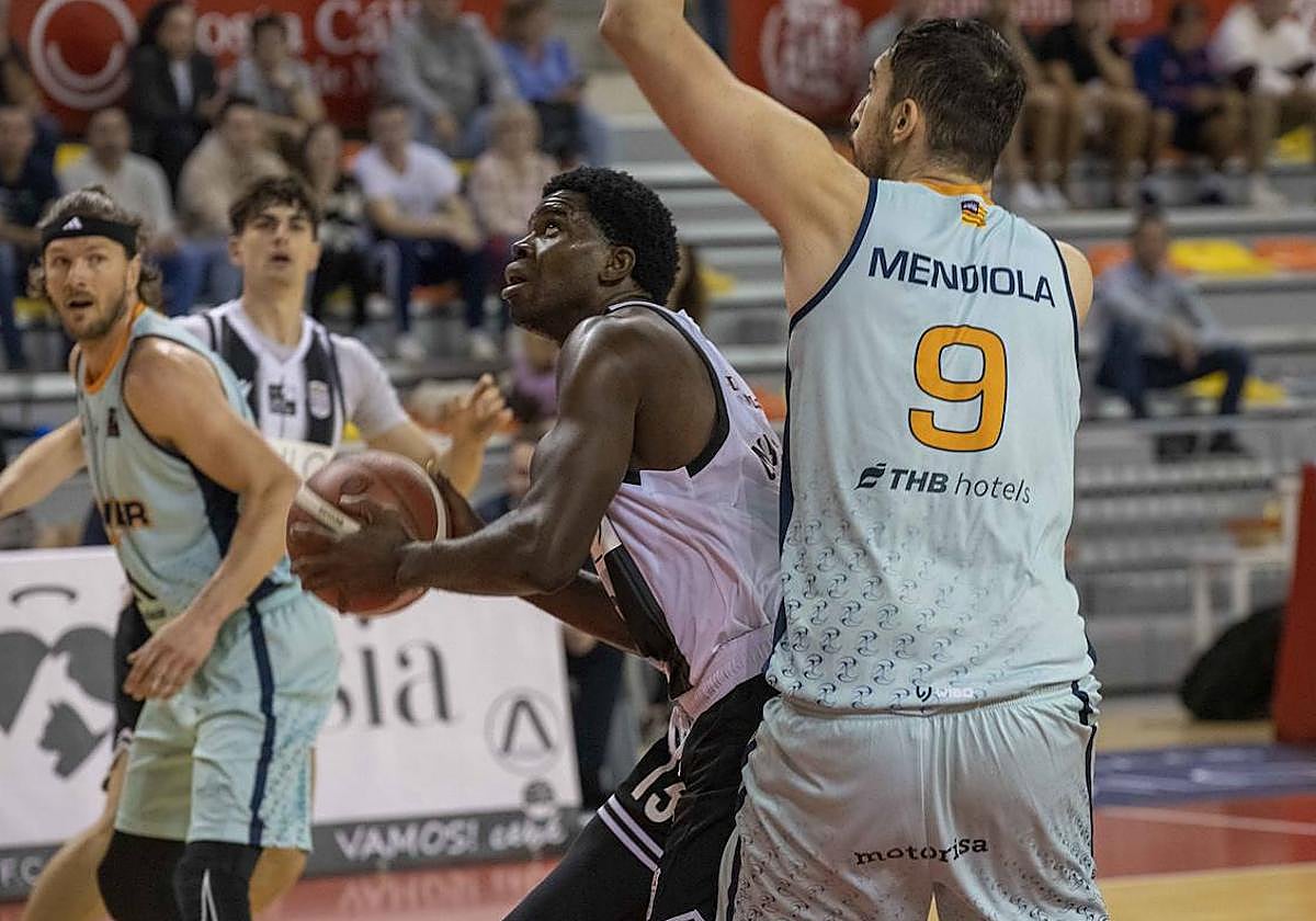 El pívot Onyi Eyisi, este domingo, durante su debut, intenta anotar bajo el aro ante la presencia del exalbinegro Sergio Mendiola.