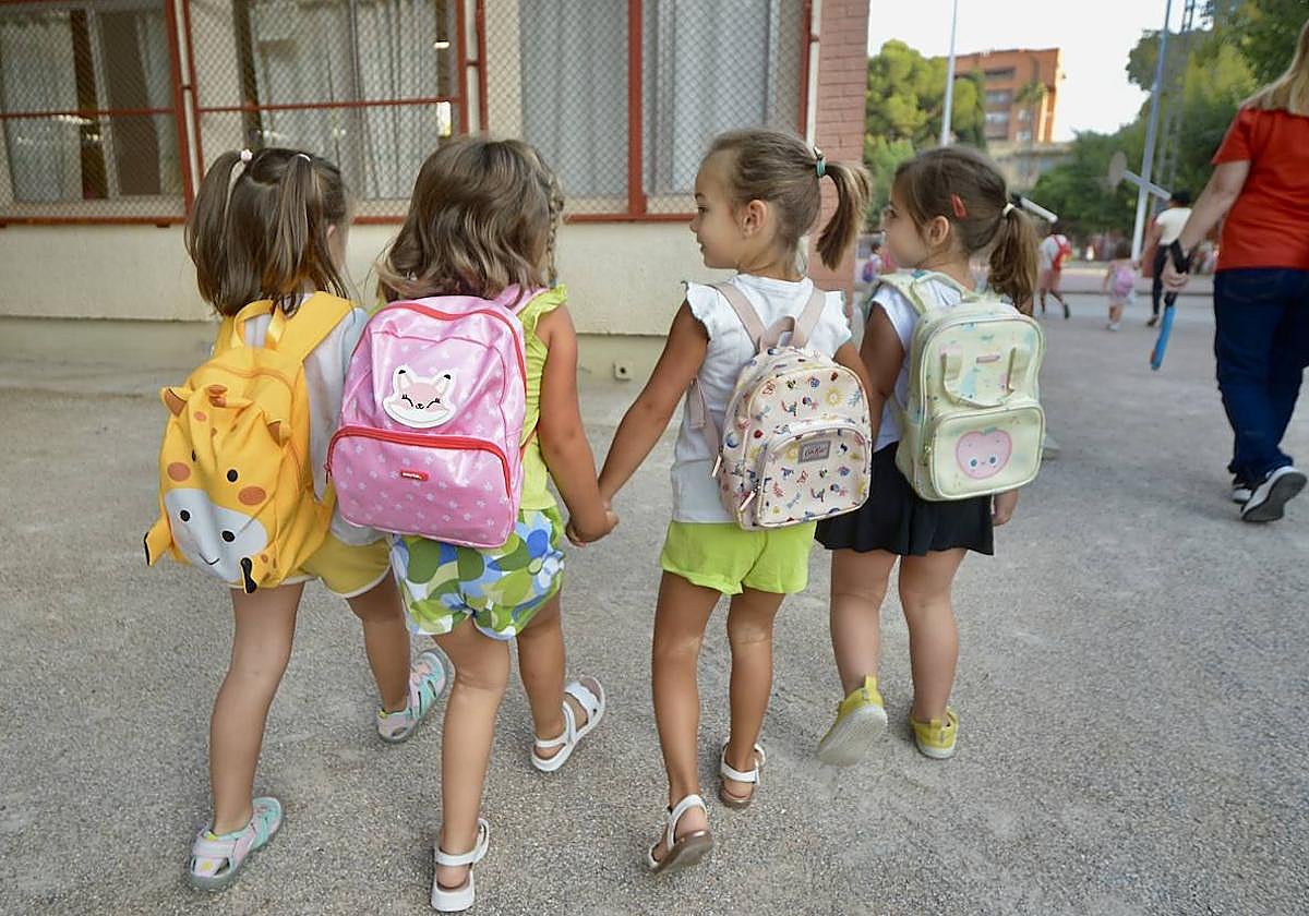 Cuatro niñas de la mano caminan por un colegio de Murcia.