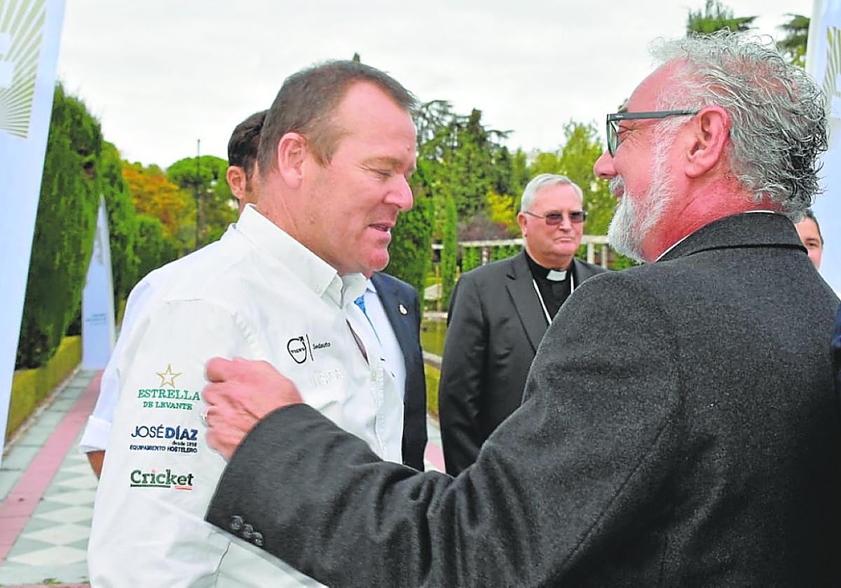 El rector de la basílica, Emilio Sánchez, entrega un pin de la Vera Cruz al chef González-Conejero.