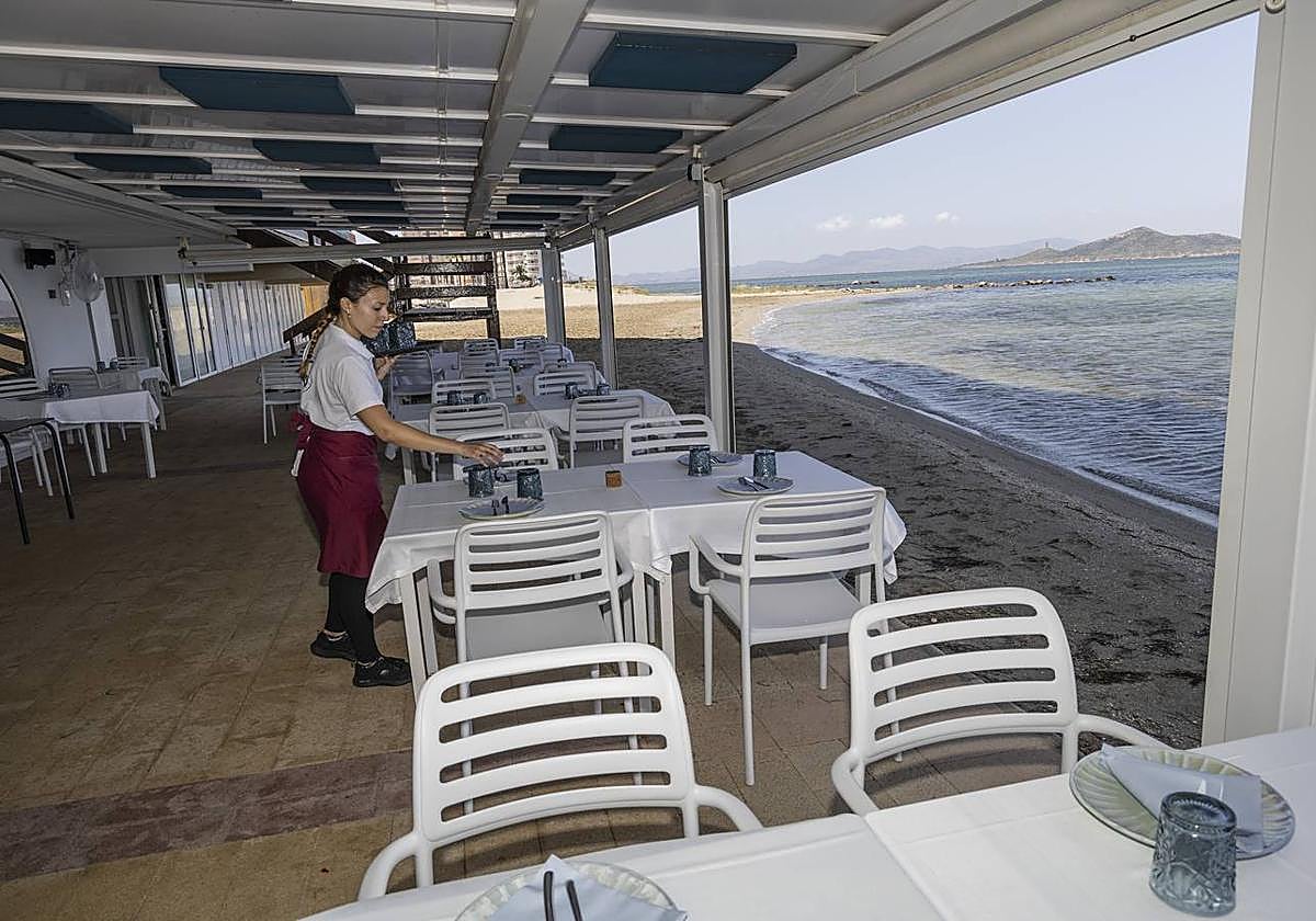 Una camarera prepara las mesas de una terraza en una imagen de archivo.