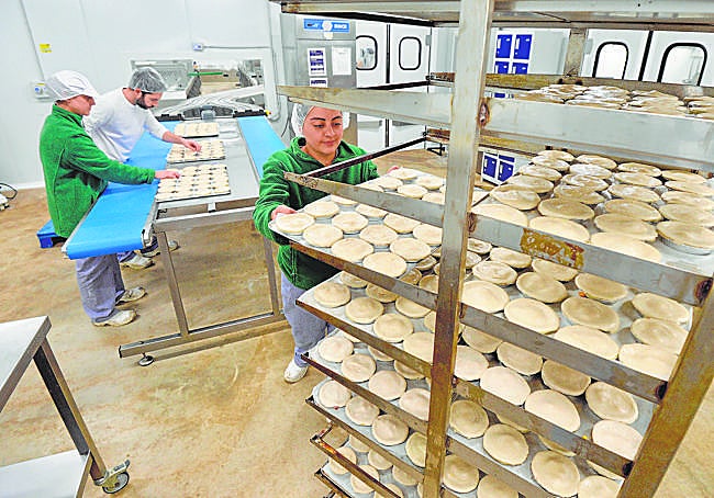 Trabajadores de la empresa preparan los pasteles para hornear en las instalaciones, con capacidad para producir unas 400.000 unidades mensuales.