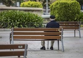 Un anciano sentado en un parque, en una imagen de archivo.
