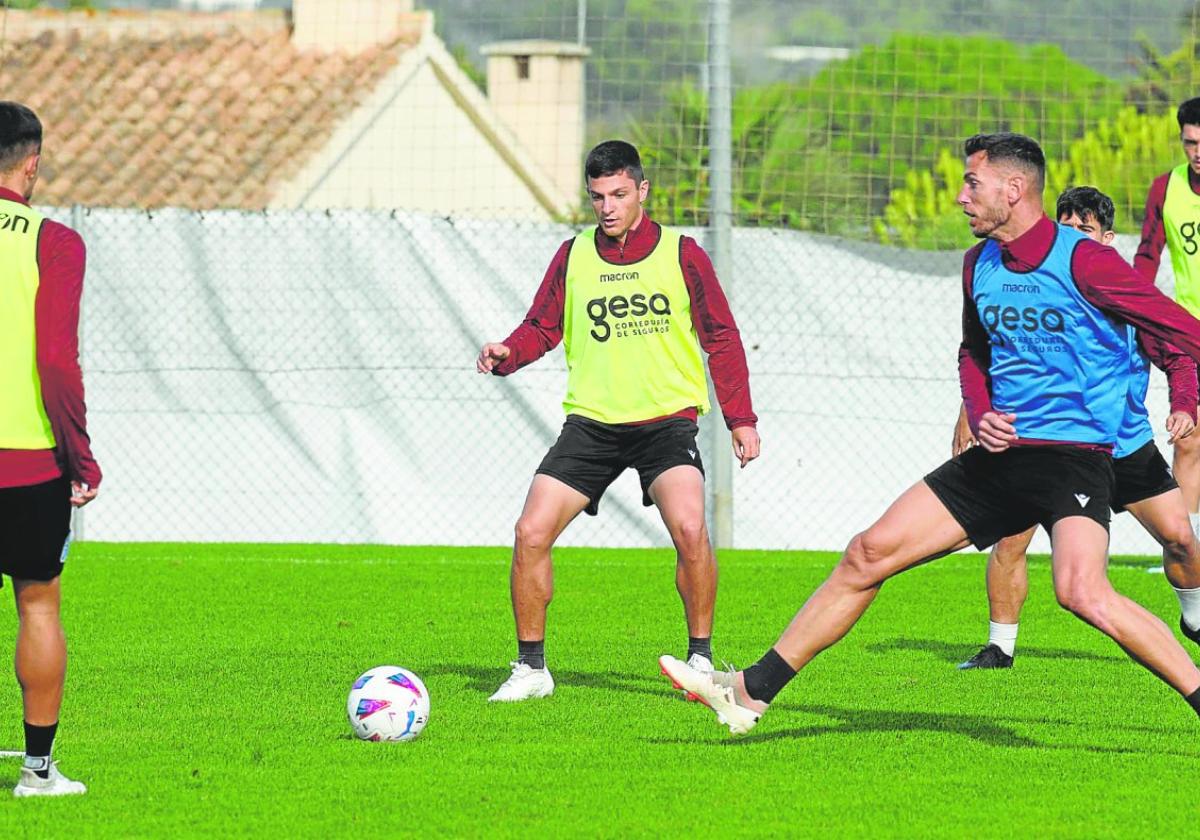 El unionense Jony Álamo se dispone a controlar el balón ante la presencia del mazarronero Pedro Alcalá, durante un entrenamiento en La Manga Club.