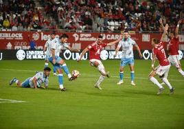 Arturo intenta alcanzar el balón entre varios jugadores del Málaga.