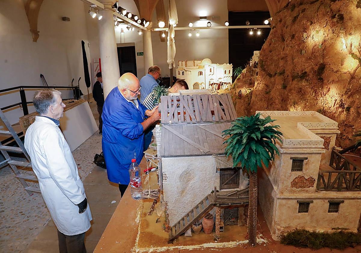 Miembros de la Asociación Belenista de Lorca durante el montaje de la maqueta en el patio del Palacio de Guevara.