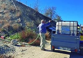Antonio Palazón, vecino de El Boquerón, llena el depósito de 1.000 litros en una balsa de riego para llevarlo a su casa.