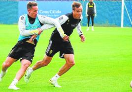 Pablo Larrea y Tomás Pina pugnan por un balón ayer en el entrenamiento del Real Murcia en Pinatar Arena.