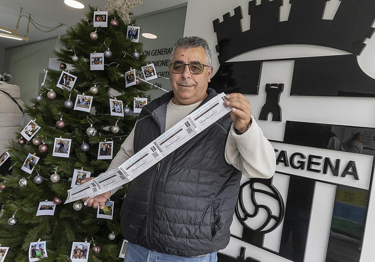 Un aficionado muestra sus entradas para el partido.