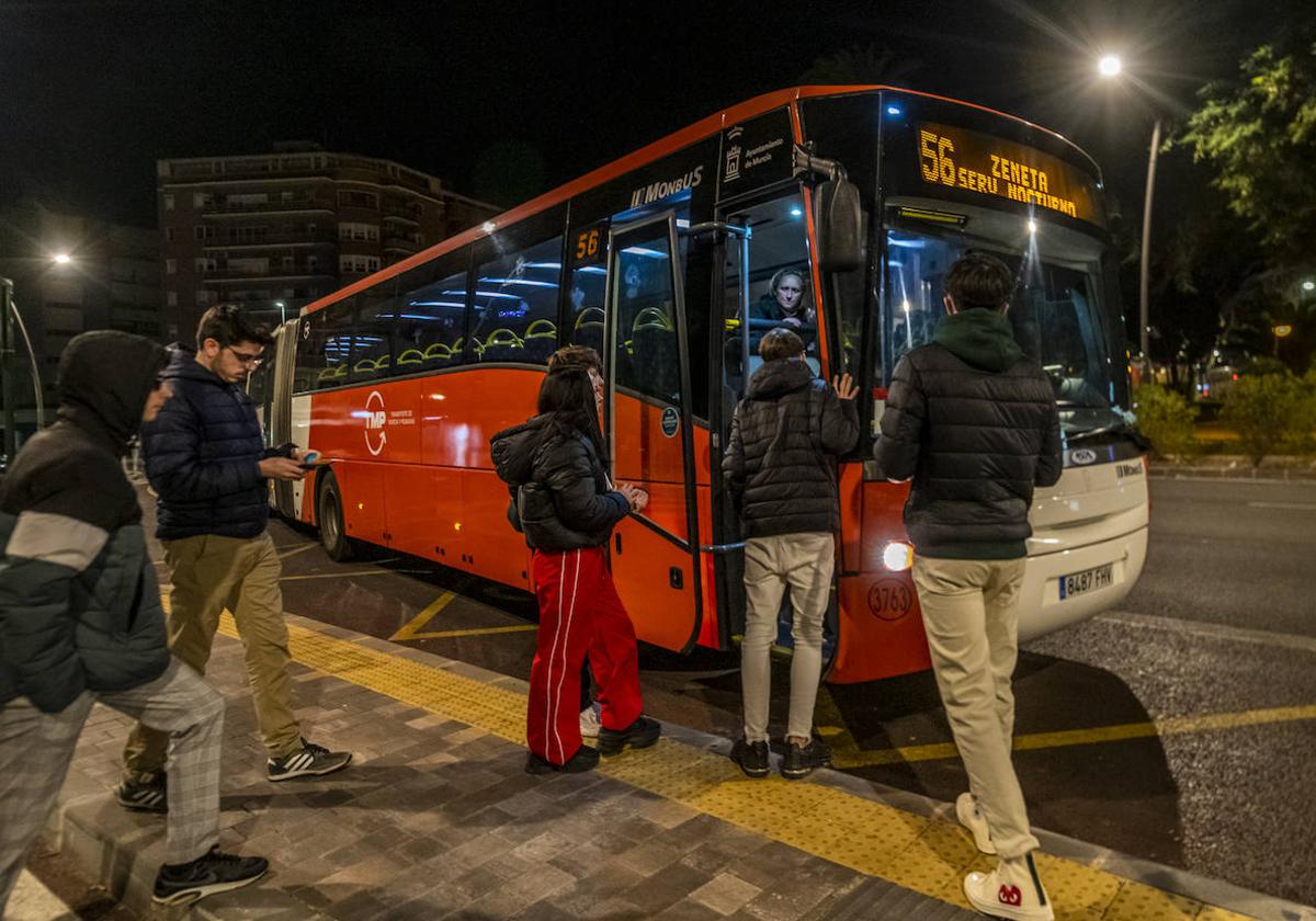 Varios jóvenes se suben al búho bus navideño en Murcia, en la madrugada de este sábado.