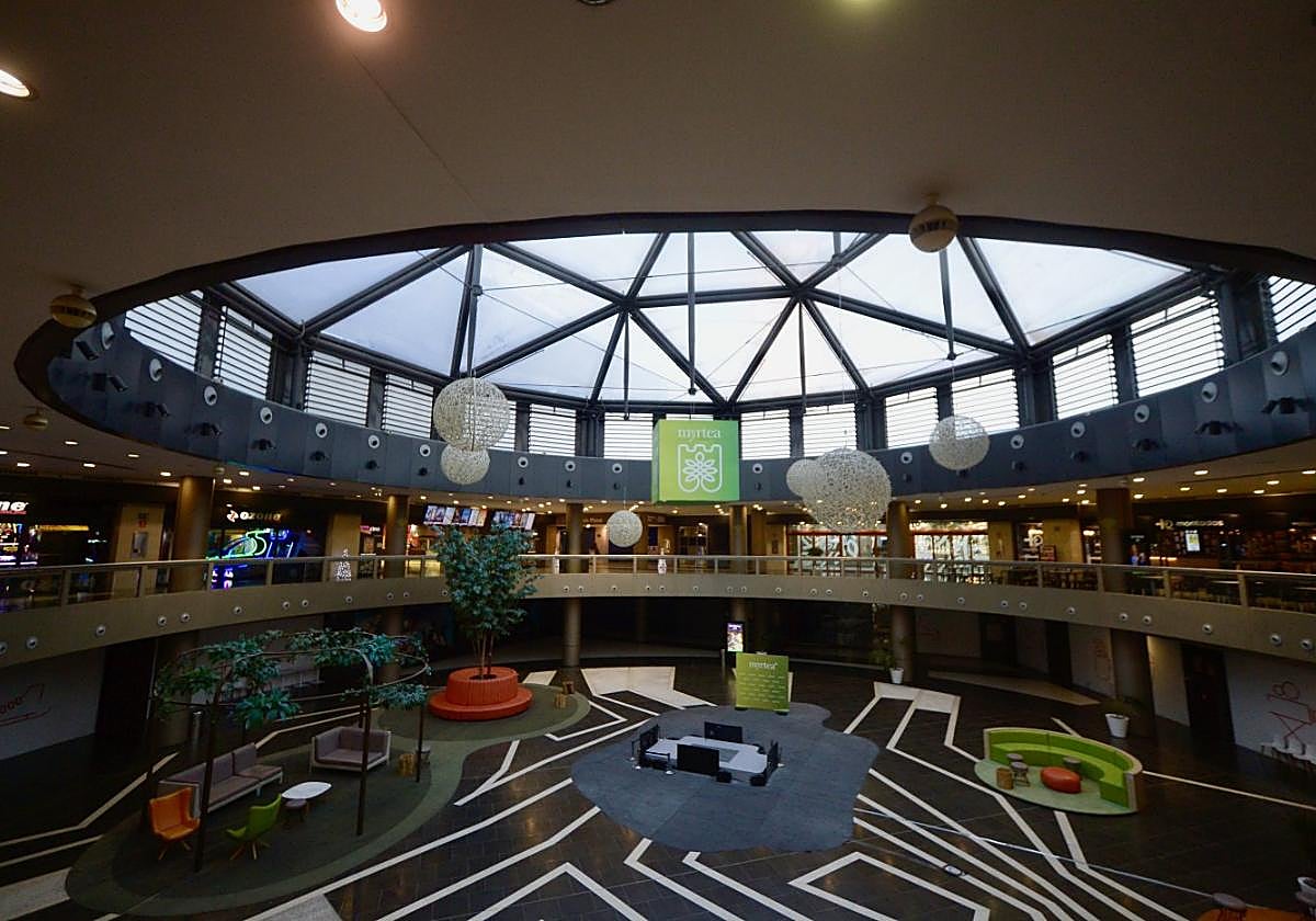 Plaza interior del centro comercial. Solo algunos de los locales de la planta superior están ocupados.