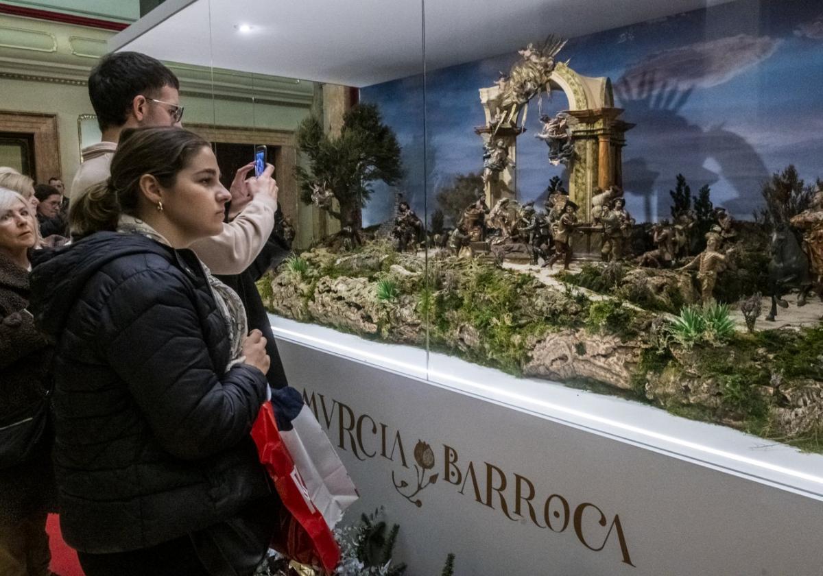 Un joven toma una fotografía del nacimiento del Belén de Salzillo, expuesto en el Salón de Plenos de La Glorieta.