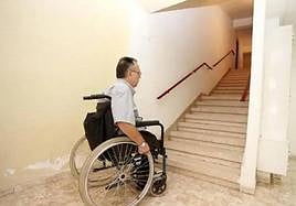 Un hombre en silla de ruedas no puede subir las escaleras de una vivienda, en una imagen de archivo.