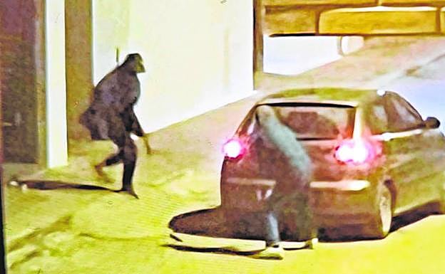 Dos encapuchados huyen en un coche, tras asaltar una farmacia en el centro de Torre Pacheco, el lunes. 