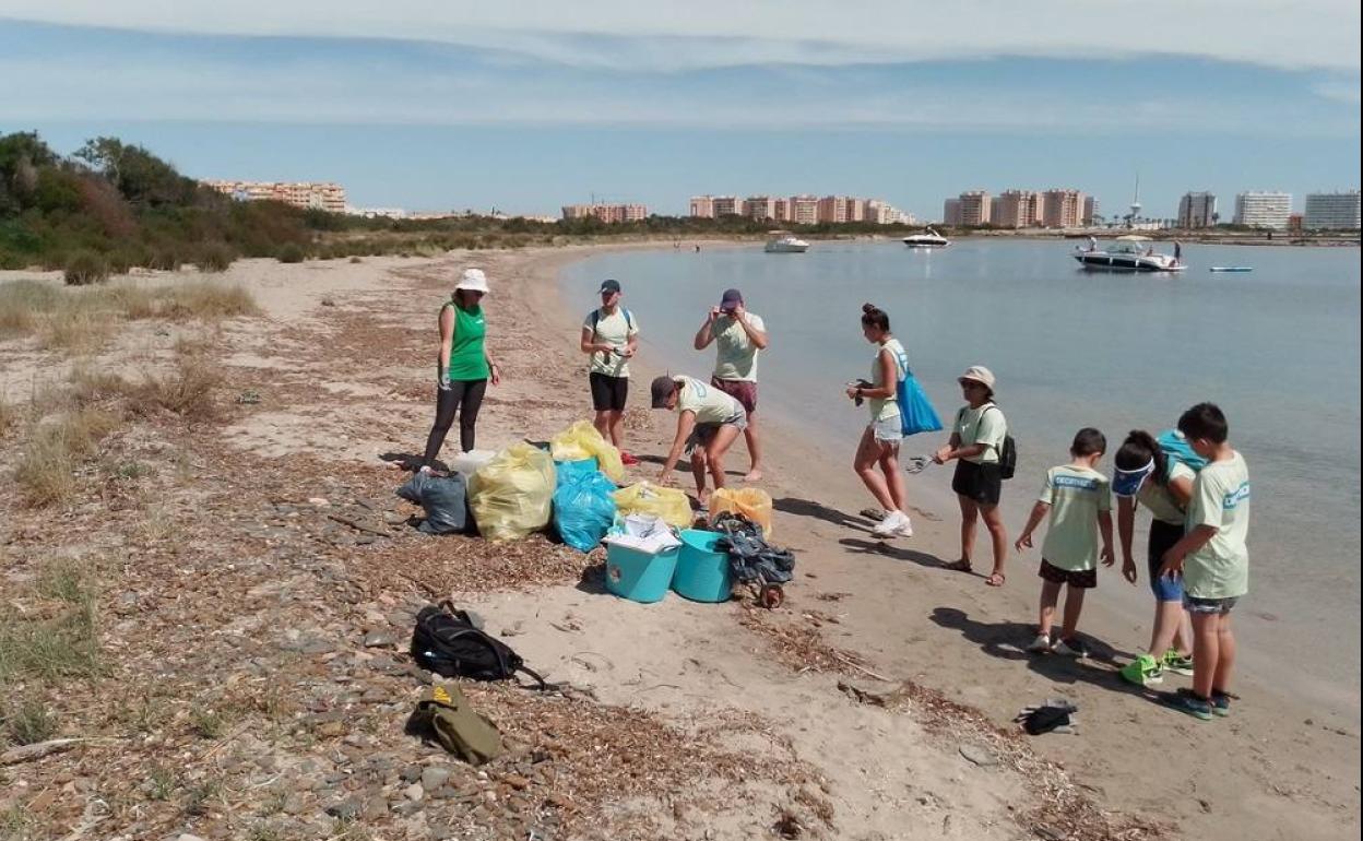 Un equipo de voluntarios recoge basura en una playa de la Región. 