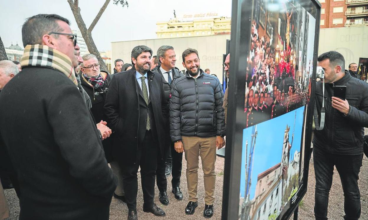 López Miras y Marcos Ortuño contemplan una de las fotos instaladas en la plaza de Colón. 