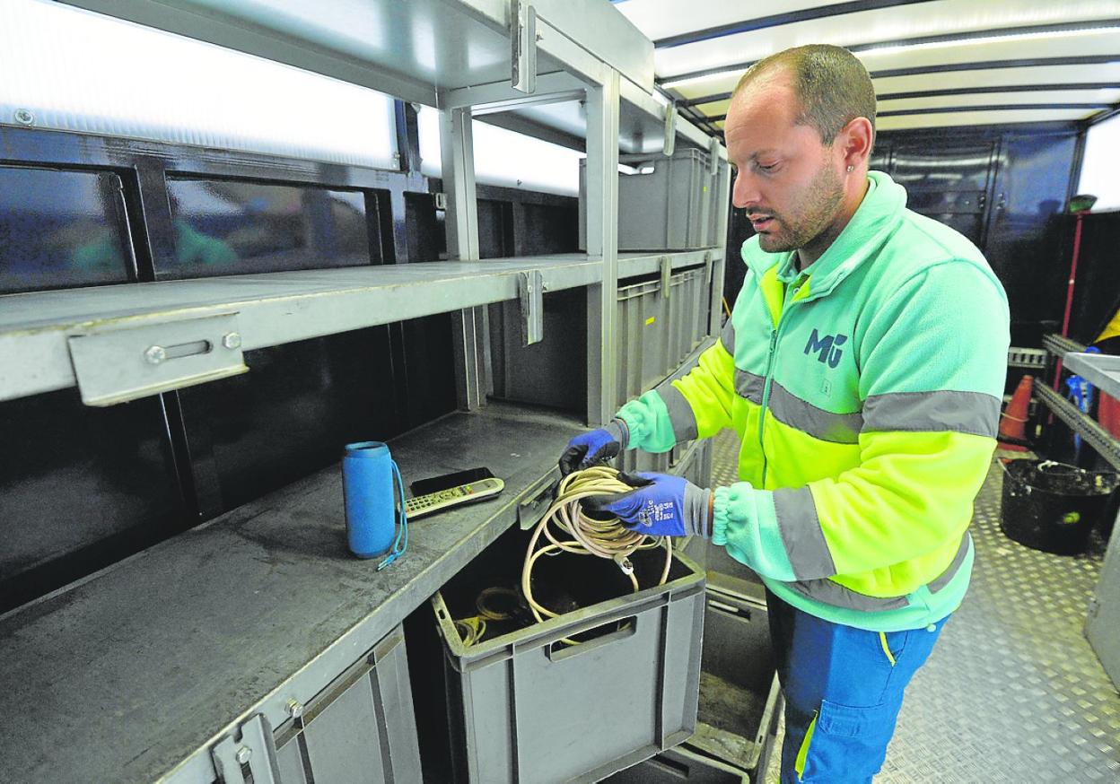 Un operario, ayer por la tarde, selecciona los objetos recogidos en un ecopunto móvil. 