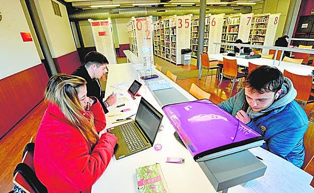 Jóvenes estudian, ayer, en la biblioteca arropados con sus abrigos. 