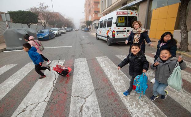 La voluntaria Antoñita deja a los niños en el colegio con el microbús de Cáritas.