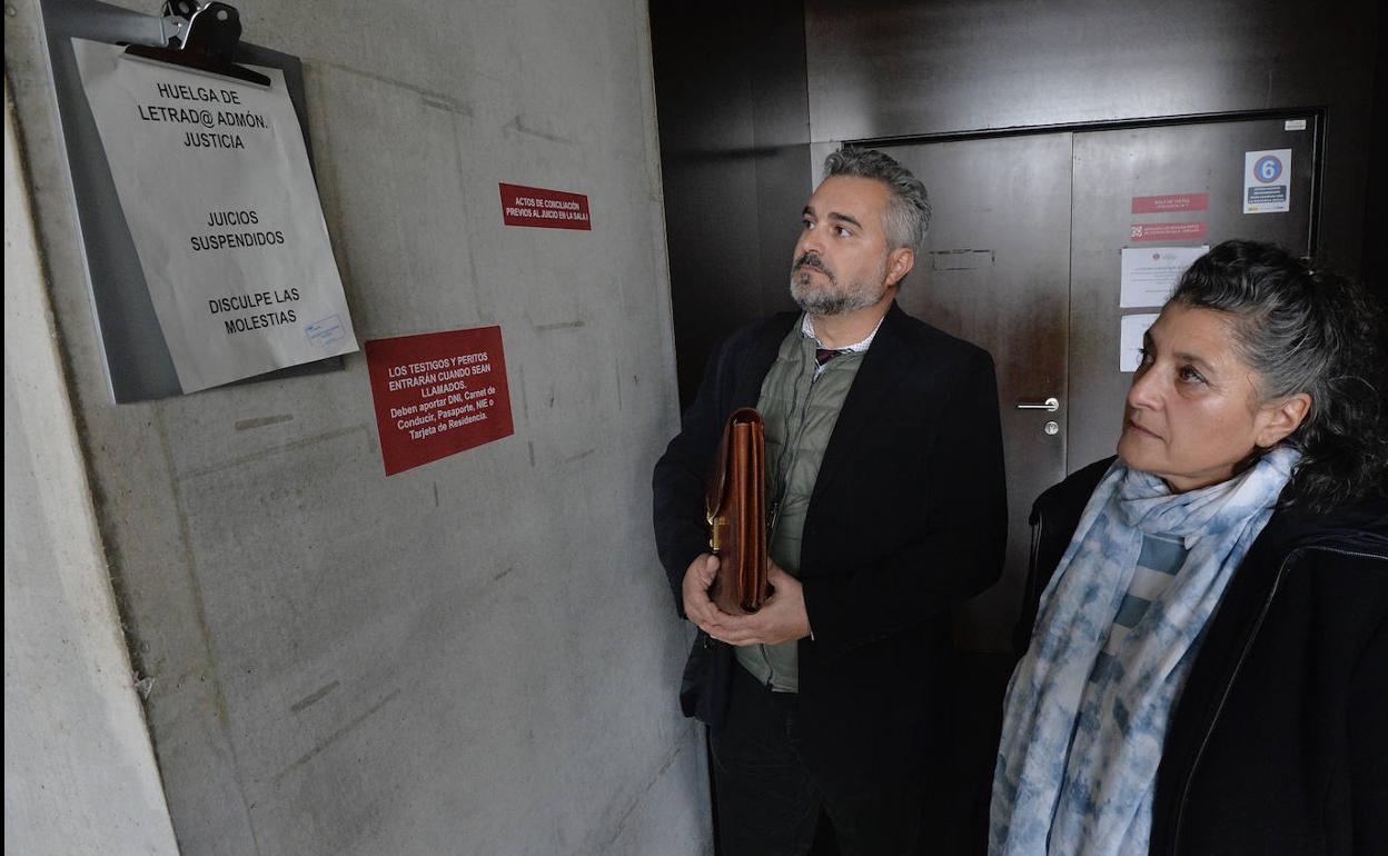 Luisa María Pérez y su letrado, Gregorio Gómez, consultando un papel en el juzgado que anunciaba la suspensión de vistas por la huelga. 