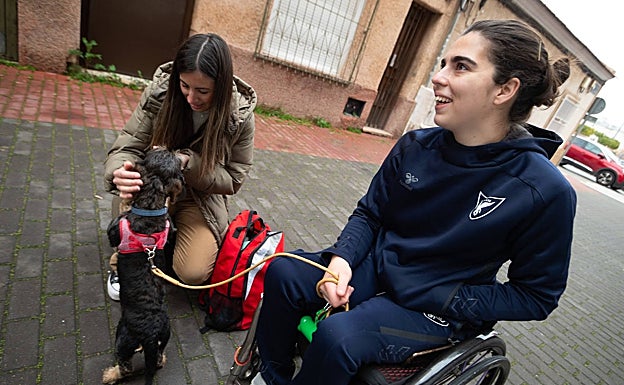 La cuidadora Laura Serrano acaricia a Pumba, la perrita de Beatriz Zudaire.