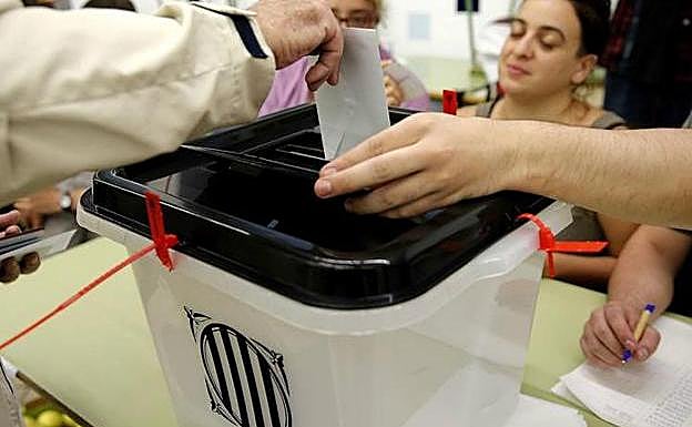 Un ciudadano deposita su voto para el referéndum indepedentista