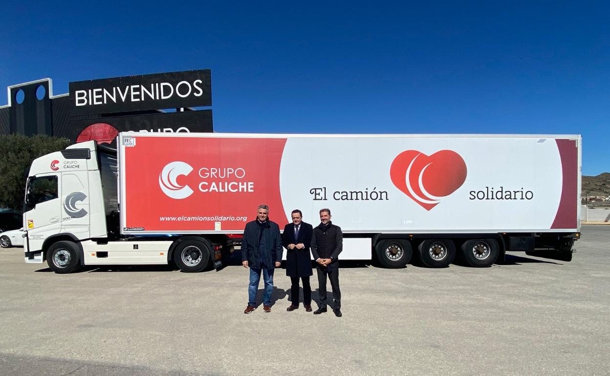 El director general de Like, José Ángel Pardo, el presidente de Croem, José María Albarracín y David Martínez, presidente de Grupo Caliche, presencian la salida del camión de las instalaciones logísticas en Baños y Mendigo.
