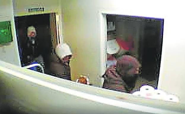 Tres encapuchados, en una panadería de Beniaján la semana pasada.