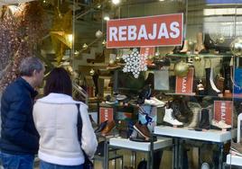 Dos personas observan la vitrina de una tienda de calzado, ayer en el centro de Murcia.