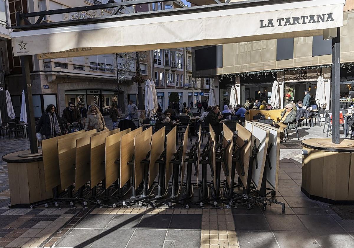 Mesas apiladas de un restaurante de la calle Puerta de Murcia, cerrado por descanso tras la Navidad.