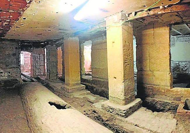 Restos de muralla (a la derecha), antemuralla y val de agua abovedado hallados en el inmueble.