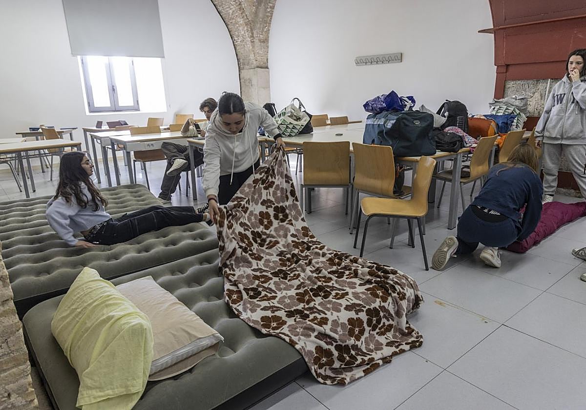 Un grupo de alumnas de Enfermería encerradas en los aularios de Antigones preparan sus camas provisionales para descansar, este lunes.