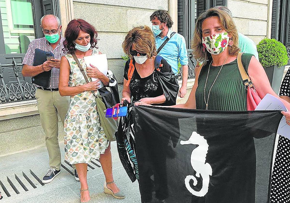 Teresa Ribera, con una bandera, y promotores de la ILP del Mar Menor, en el Congreso de los Diputados en 2022.