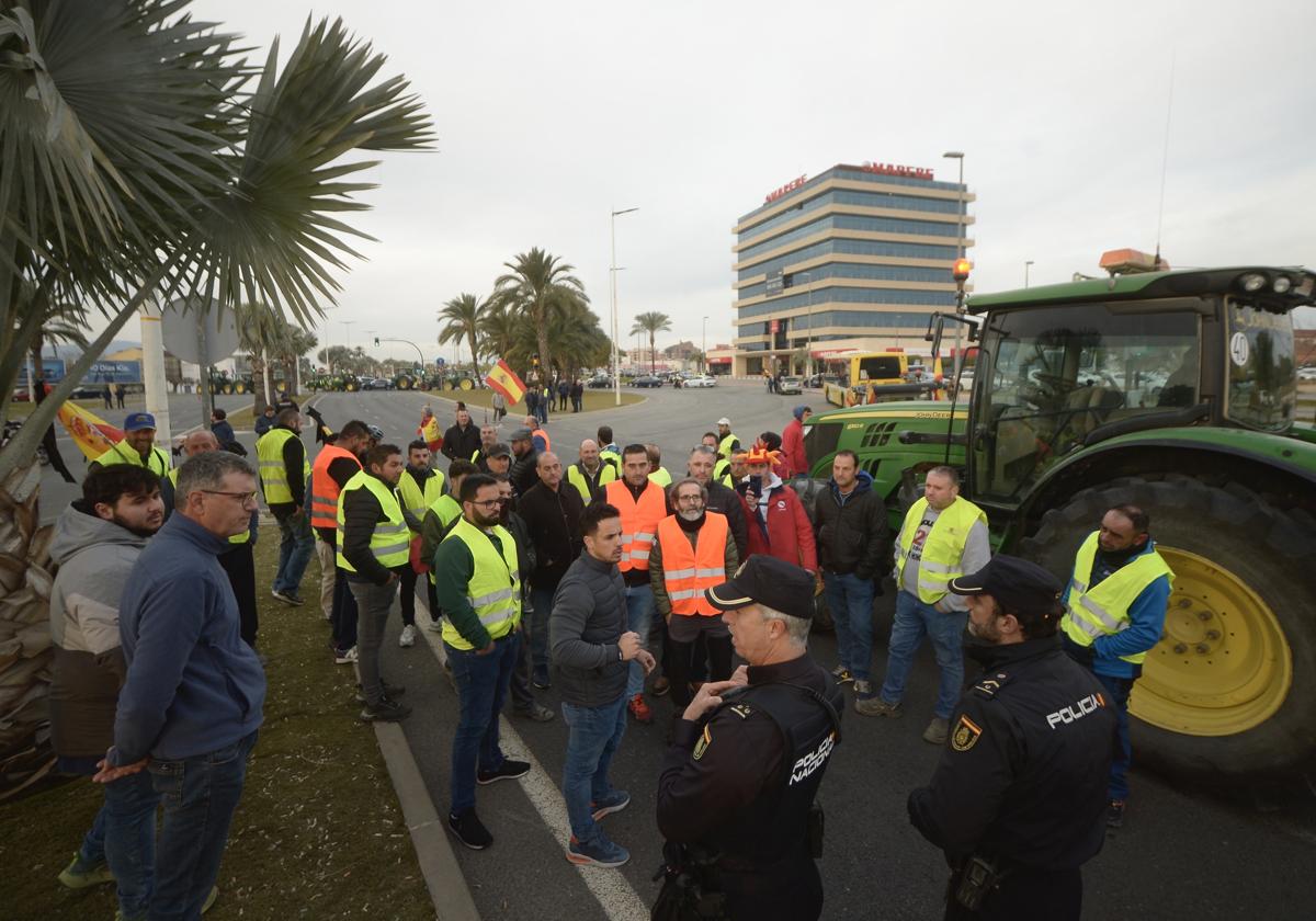 Manifestantes hablan con dos policías nacionales, este martes en la avenida de Los Dolores.