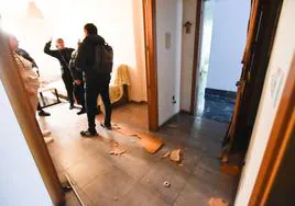 Destrozos en la vivienda de La Alberca. En vídeo, dos de los empleados de la empresa de desokupas en una de las casas del bloque.