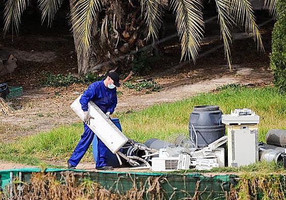 Uno de los funcionarios deposita algunos de los objetos decomisados.