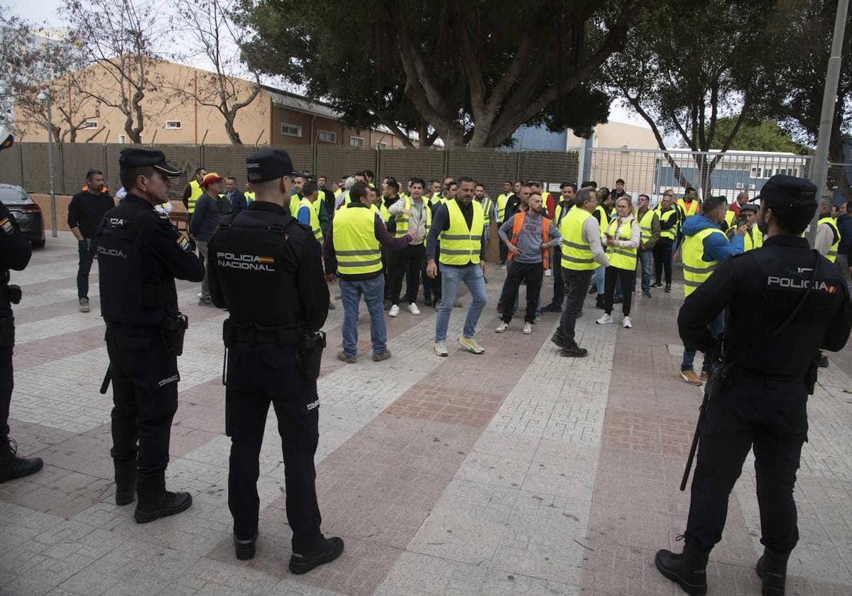 Agentes de la Policía custodian el garaje de la Asamblea Regional, este miércoles, mientras un grupo de agricultores increpa a Fernando López Miras.