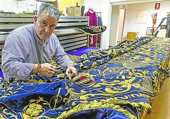 Juan Luis Aguirre con el manto de la Virgen Dolorosa, en el almacén marrajo de Bretau.