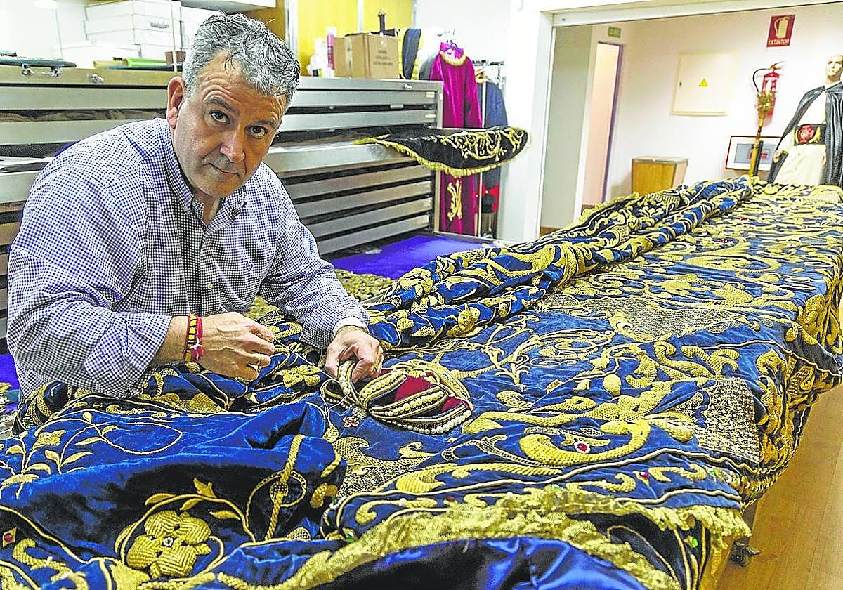 Juan Luis Aguirre con el manto de la Virgen Dolorosa, en el almacén marrajo de Bretau.