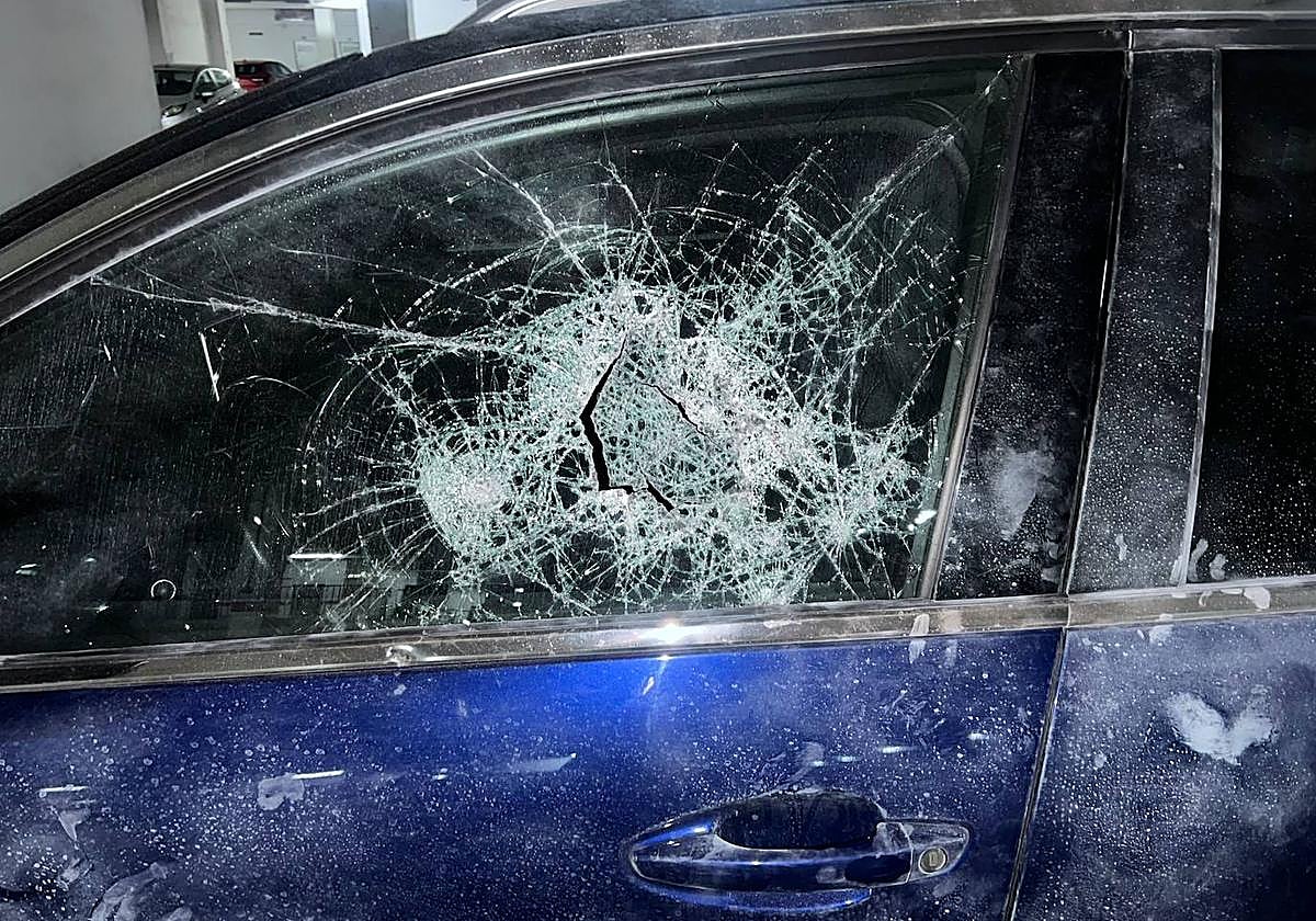 Uno de los vehículos con los cristales destrozados.