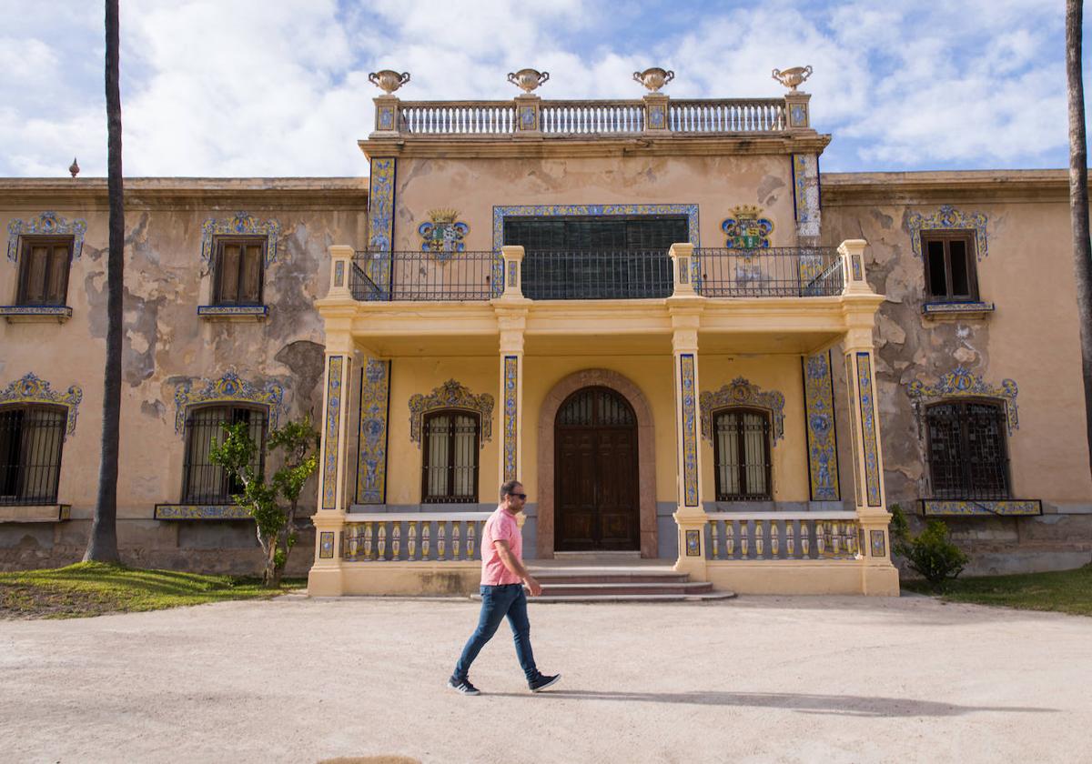 Un hombre pasea frente a la fachada principal del palacio, que sufre importantes humedades.