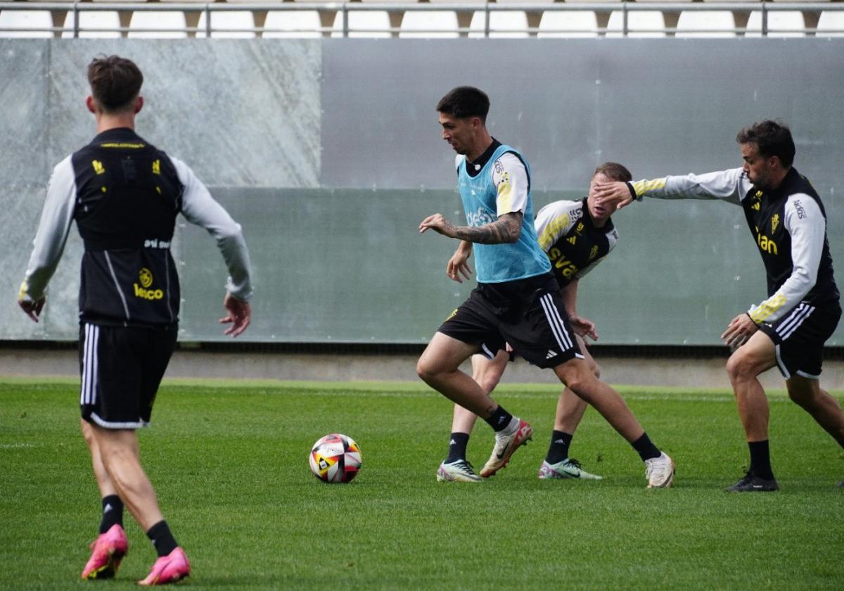 Andrés conduce un balón perseguido por Pedro León durante un entrenamiento del Real Murcia.