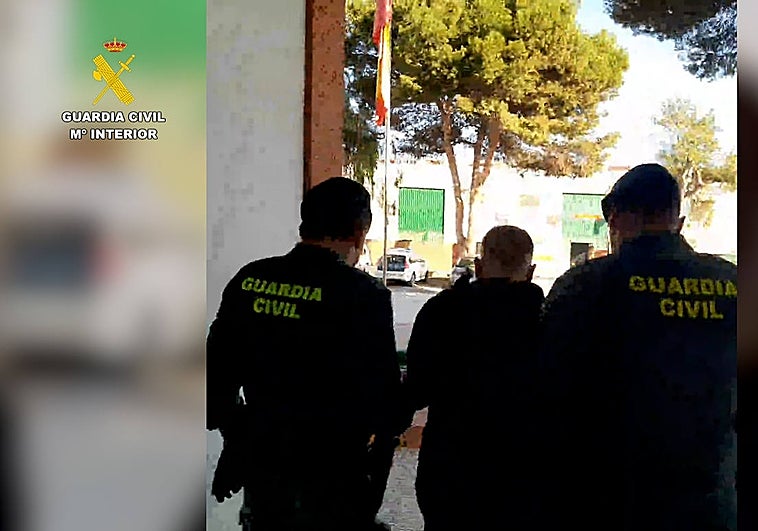 Dos agentes trasladan a uno de los detenidos en la 'Operación Dhakiras'.