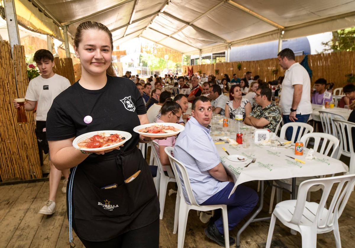 Una camarera de una barraca sostiene dos platos de ensalada murciana, en las Fiestas de Primavera de Murcia 2023.