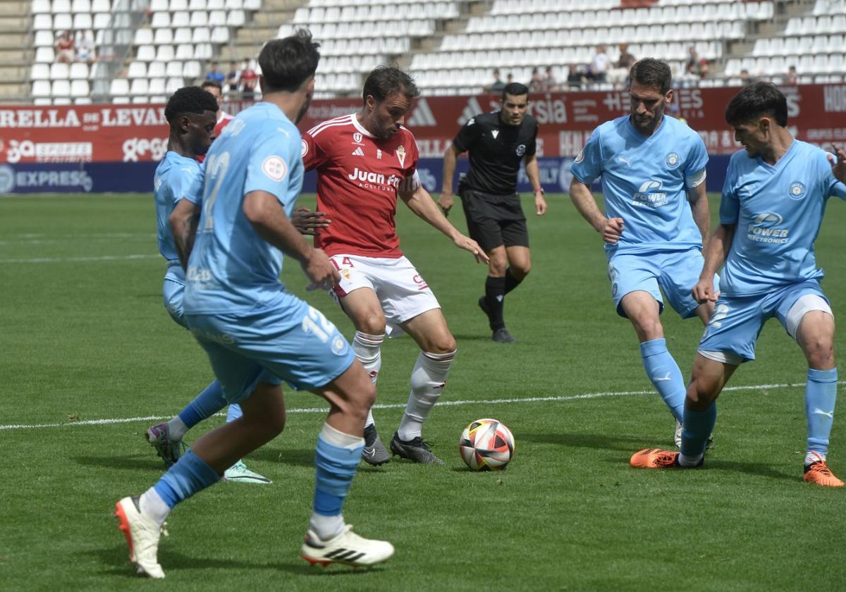 Pedro León, del Real Murcia, intenta jugar en el área rodeado de jugadores de la UD Ibiza.