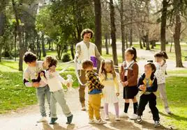 El paseador de niños lleva a un grupo al parque con un arnés.