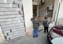 Dos vecinas, junto a una de las entradas selladas del edificio.