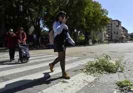 Peatones cruzan una calle durante un episodio de fuertes vientos.