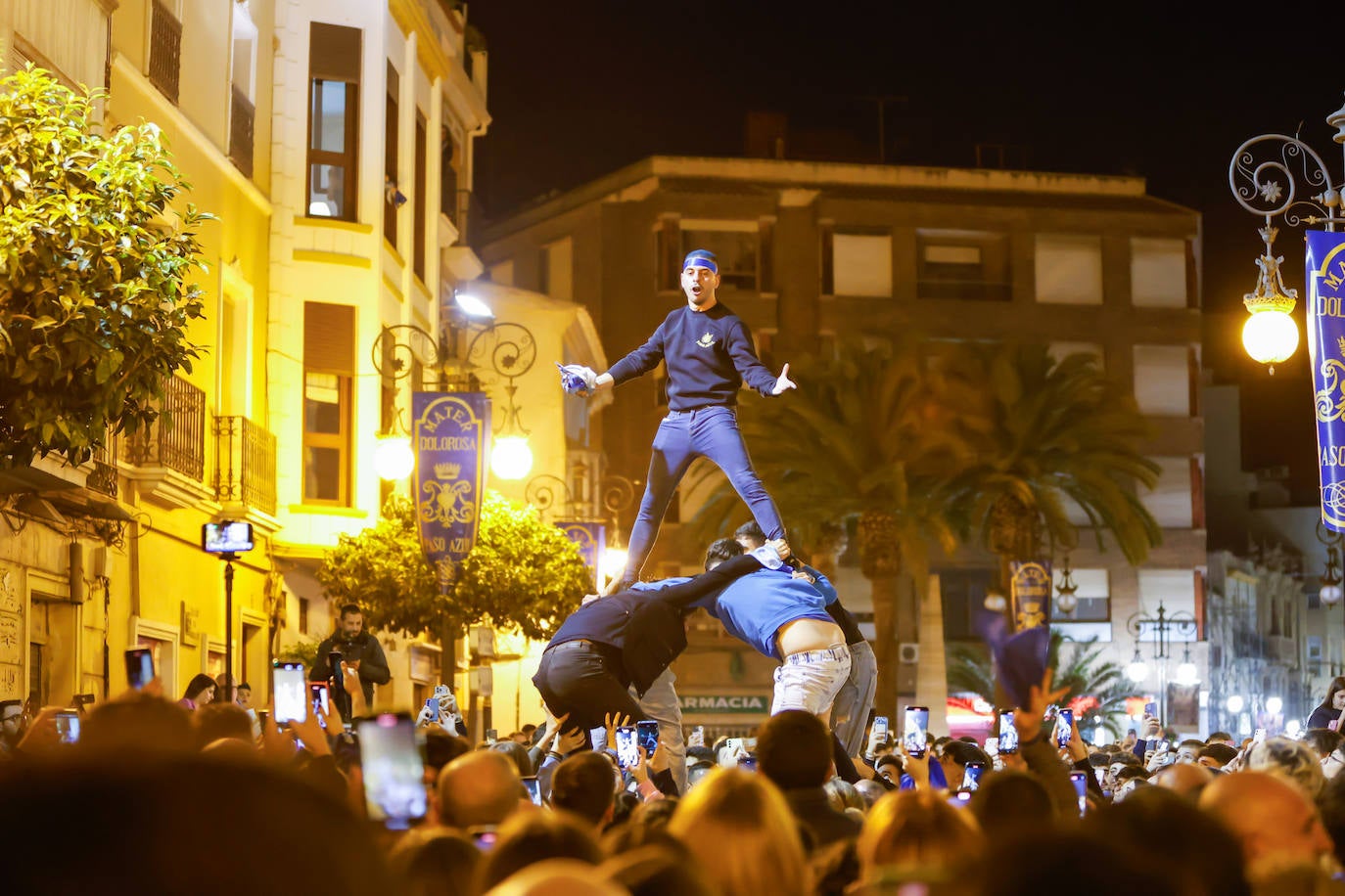 Un azul lanza vítores a la Virgen desde lo alto de una torre humana.